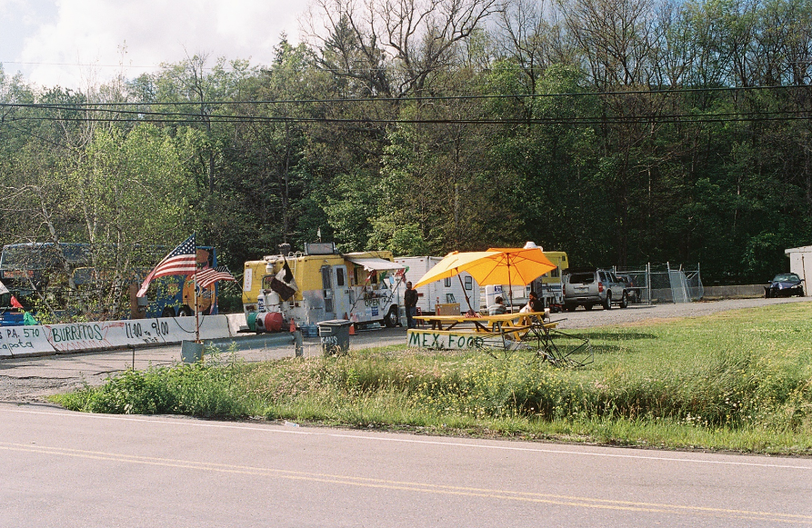 A color photograph of a Mexican food stand by a road.